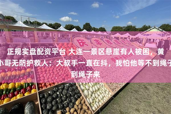 正规实盘配资平台 大连一景区悬崖有人被困，黄鞋小哥无防护救人：大叔手一直在抖，我怕他等不到绳子来